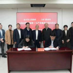 Senior officials at desk during signing ceremony